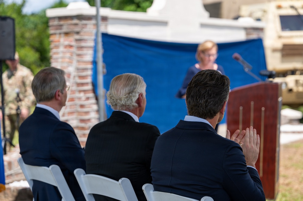 On the dais at the renaming: Treasury Secretary Scott Bessent, Gov. Henry McMaster, and Secretary of War Pete Hegseth as Sen. Darline Graham Nordone speaks, August 10, 2026. Rep. Nancy Mace is not among the officials on stage.