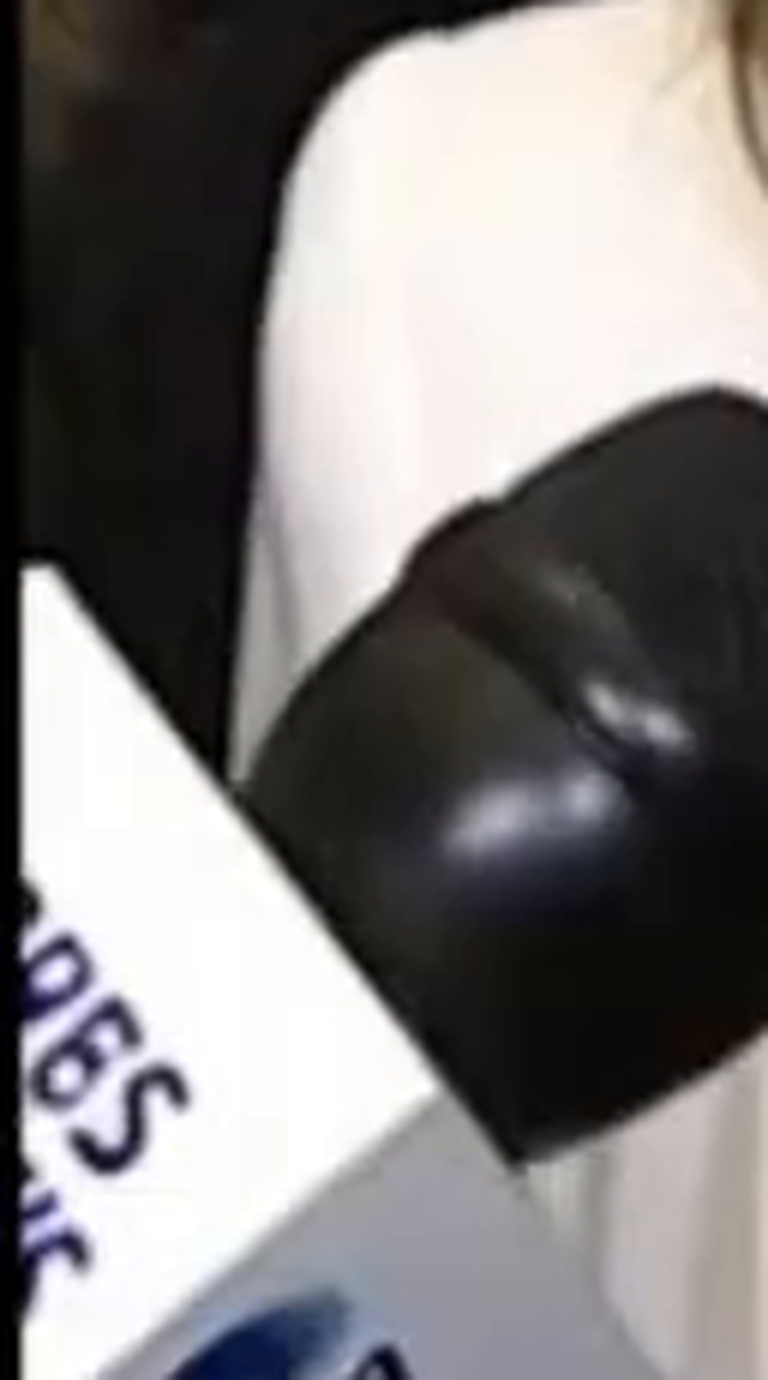 Crop of a third partial microphone flag cut off at the upper-left edge of the frame, repeating the same fabricated left-flag design