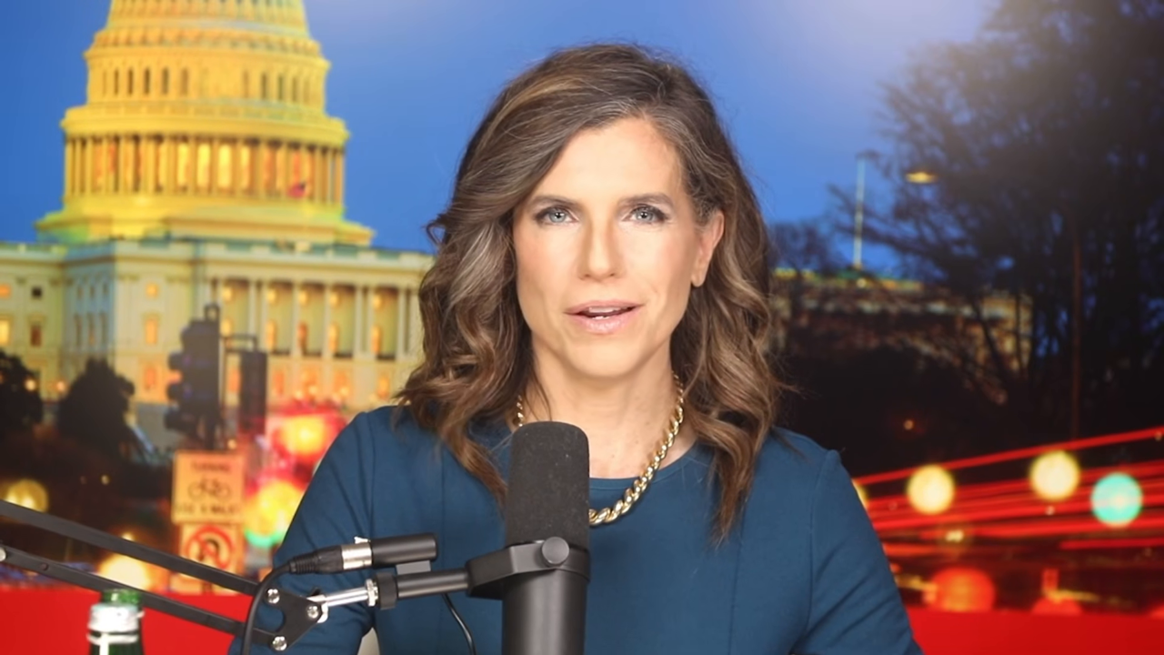 Still: Mace at the boom microphone in her studio setup with a produced Capitol backdrop, from the August 11, 2026 video